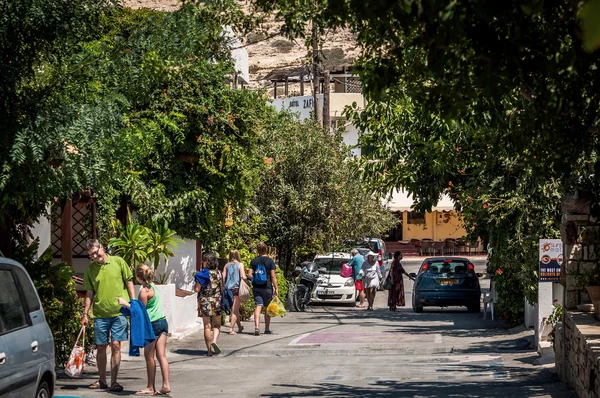 Lidé chodí na zelené ulici města Matala na ostrově Kréta, Řecko — Stock fotografie