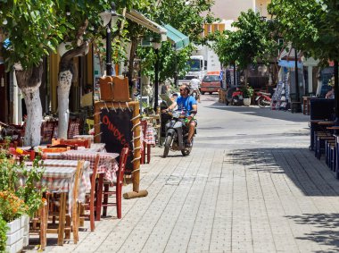 Motosikletçi Paleochora kasaba Caddesi'nde Yunanistan Crete adada kullanıyor