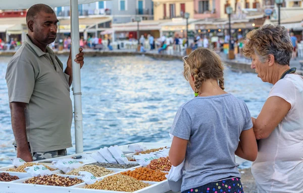 Young girl and old woman buy nuts from street seller — Stock Photo, Image