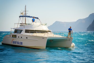 Santorini Island, Yunanistan sahil şeridi yakınındaki motor yat sürüş iki adam