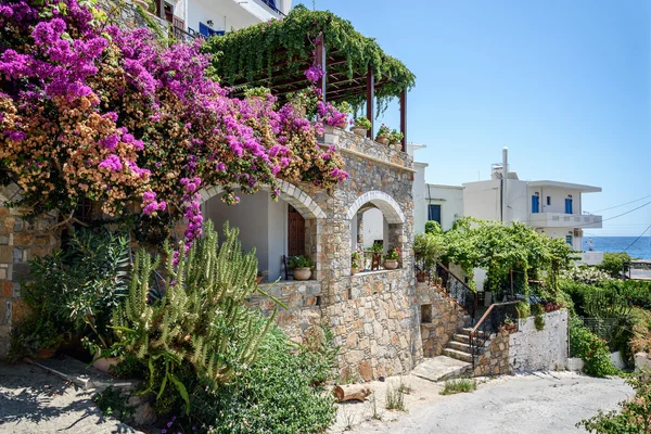 Traditional Greek stone house with bougainvillea flowers around — Stock Photo, Image