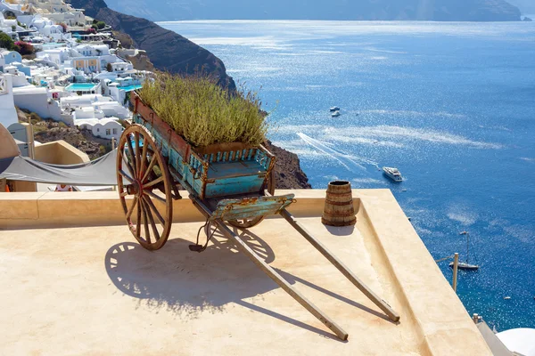 Decorative old cart with flowers on a roof terrace in Oia, Santorini — Stock Photo, Image