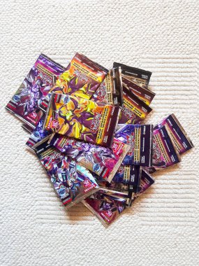 Yepyeni bir Yu-Gi-Oh destesi yığını halının üzerinde duruyor. Kart oyunları yığını ticareti
