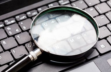 Laptop klavyesinde büyüteç var. Bir netbook anahtar üzerinde Loupe. Teknoloji dosya arama aracı konsepti, veri adli tıp, bilgisayar suçları ve aygıt araştırması, daha yakından bakın, soyut veya yakın çekim yok.
