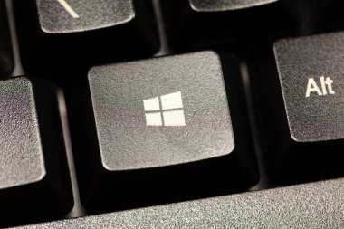 Microsoft Windows 10 işletim sistemi logosu siyah bir masaüstü bilgisayar klavyesinde, yakından görülüyor. PC OS düğmesi makro, aşırı yakın plan, basit üst görünüm
