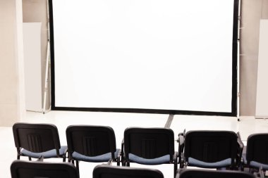 Boş bir şirket multimedya sunum ekranının önündeki sıra sıra ofis sandalyeleri, boş konferans salonu iç mekan, boş konferans salonu, halka açık etkinlik, çalışan eğitimi, eğitim, hiç kimse, kopyalama alanı.