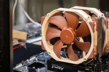 Geniş çift vantilatörlü modern bir masaüstü bilgisayar ana kartı Noctua CPU hava soğutucusu takılı, RAM modülleri görünür, açık bank bilgisayarı yakın çekim, parçalardan bir PC montajı