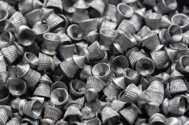 Yığının içinde yüzlerce gümüş metal havalı tüfek saçması, diabolo cephane dokusu arka plan, küçük kalibreli atış, av sporu, malzeme yükleme şablonu, tam çerçeve, insan yok.