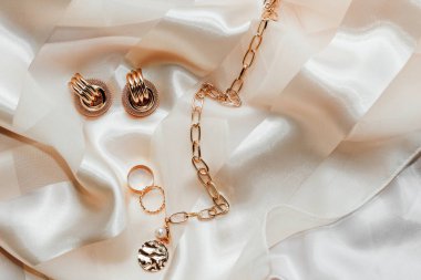 Kadın mücevherleri, altın zincir, ipek arka planda moda mücevherler..