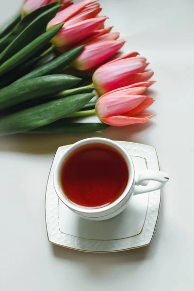 ピンクのチューリップの花束とお茶のカップ 朝食の構成のミニマリズム 春のコンセプト — ストック写真