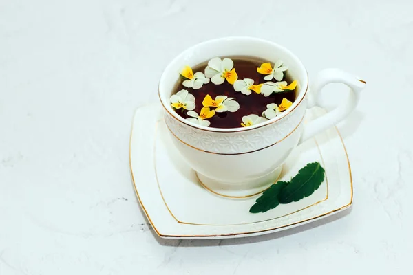 花で飾られた金の境界線と美しい白いカップ ハーブグリーンの健康茶 営業会計の設計 — ストック写真