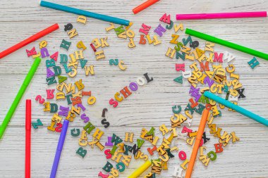Okul kreatifi Flatley. Ahşap beyaz bir masanın üzerinde çok renkli harfler var..