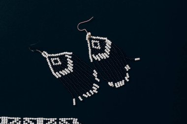 Siyah arka planda siyah ve beyaz el yapımı boncuklu küpeler..