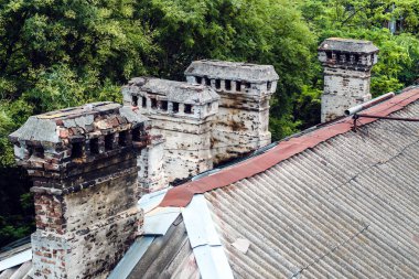 Antik taştan yapılmış bacaları olan eski evlerin çatıları..