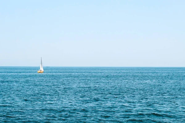 Mavi denizde yelken açan turist teknesi.