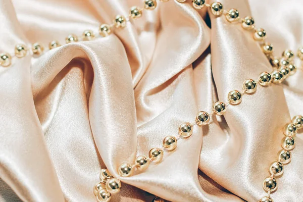 Glänsande Gyllene Texturerat Silke Bakgrund Veck Med Pärlor — Stockfoto