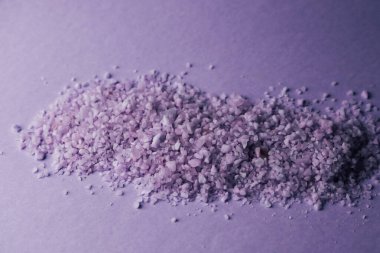 Mor kaya tuzu, eşsiz dokusu ve canlı rengini sergileyen basit bir yüzeye sanatsal bir şekilde yayılır. Işık kristallerden yansıyarak doğal güzelliğin çekici bir sahnesini oluşturuyor..