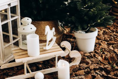 Büyüleyici bir kış süslemesinde beyaz mumlar, ahşap bir kızak ve şenlikli bir yeşillik bulunur. Sahne doğal ahşap parçalarının arasında sıcak atmosferi güçlendiren bir fenerle kurulmuştur..