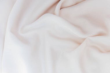 Yumuşak beyaz bir kumaş zarif bir şekilde yüzeyde yatar ve nazik kıvrımlar ve kıvrımlar yaratır. Malzeme, ışığı yansıtıyor. Huzurlu ortama zarafet katıyor. Görsel cazibeyi arttırıyor..