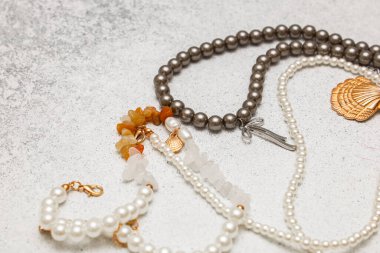 Birkaç parça mücevher hafif bir yüzeye yerleştirilmiştir. Koleksiyonda bilezikler ve dekoratif tılsımlar yer alıyor. Farklı malzemeler ve renkler her öge için farklı bir görünüm yaratır.