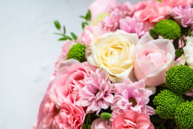 Bir bukette pembe ve beyaz güllerin yanı sıra pembe kasımpatılar ve yeşil aksanlar yer alır. Çiçekler bir kutlama ya da hediye için özenle düzenlenir. Ekran ortama neşe katıyor..