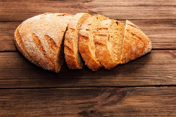 Taze ekmek birkaç parçaya ayrılır ve ahşap bir masaya konur. Ekmeğin içi kabuklu ve yumuşak tereyağlı ya da sandviçlerde kullanılmaya hazır..