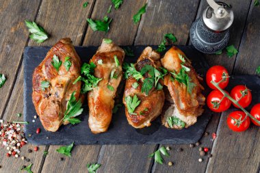 Ahşap zeminde baharat ve domatesli siyah tahtada kuzu eti.