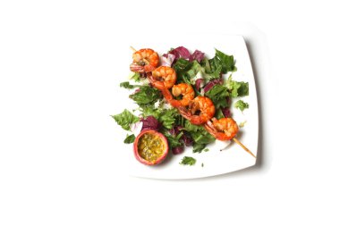 Beyaz tabakta tutkulu meyveli ızgara karides ve taze salata. Üst Görünüm, Düz Yat.
