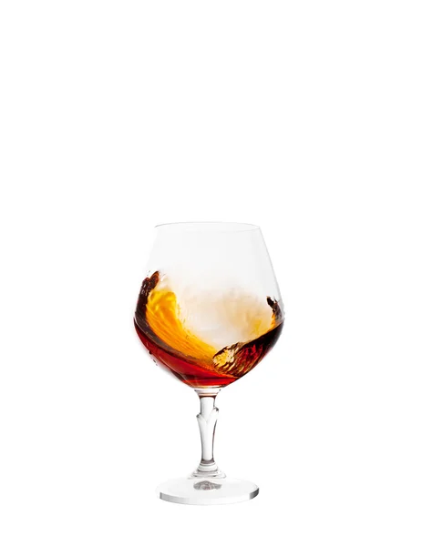 Glass with brandy and splashes isolated on white background — Stock Photo, Image