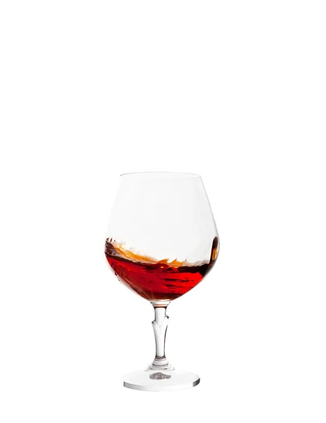 Glass with brandy and splashes isolated on white background — Stock Photo, Image