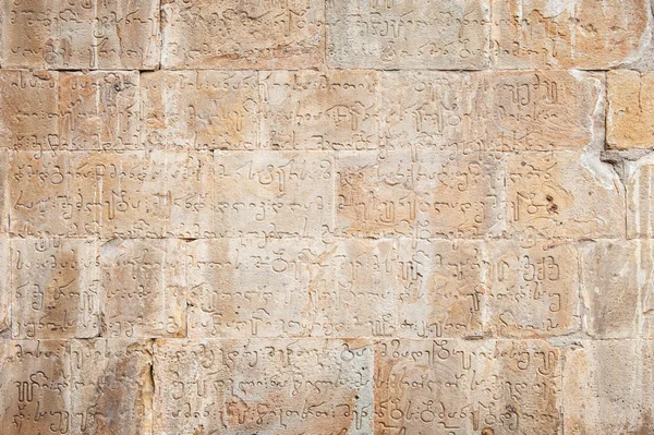 Cihlová zeď s gruzínskou dopisy — Stock fotografie