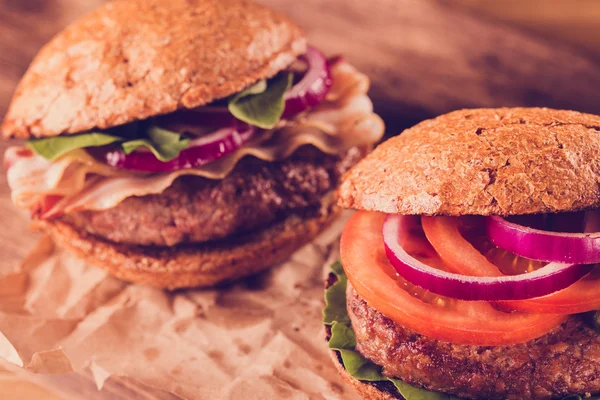 Bir kesme tahtası üzerinde iki hamburger yakın çekim. — Stok fotoğraf