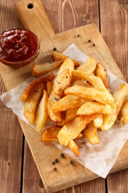 Eski ahşap kesme tahtası üzerinde patates kızartması