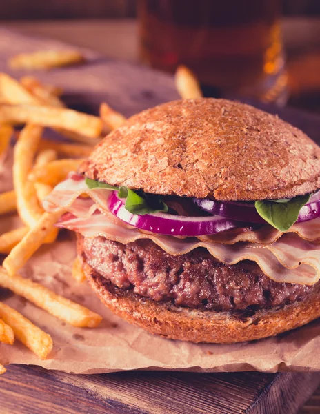 Hamburger a hranolky zblízka na vintage stylu. — Stock fotografie