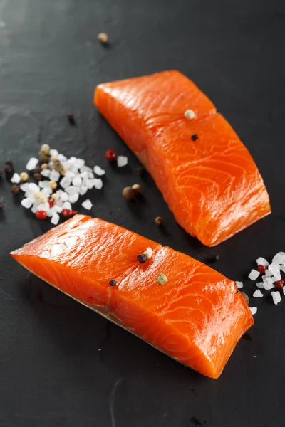 Two pieces Salmon with herbs on black background. — Stock Photo, Image