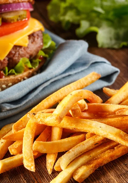Burger och pommes frites på trä bakgrund. — Stockfoto