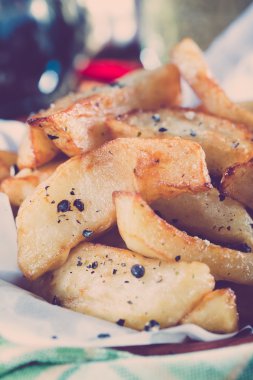 Fried Potatoes in a bowl and beer on background.