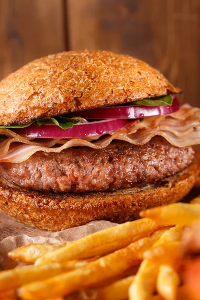 Hamburguesa y papas fritas sobre fondo de madera. —  Fotos de Stock