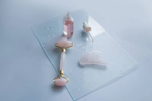 Facial massage attributes: Guasha scraper, cosmetic oil and facial roller