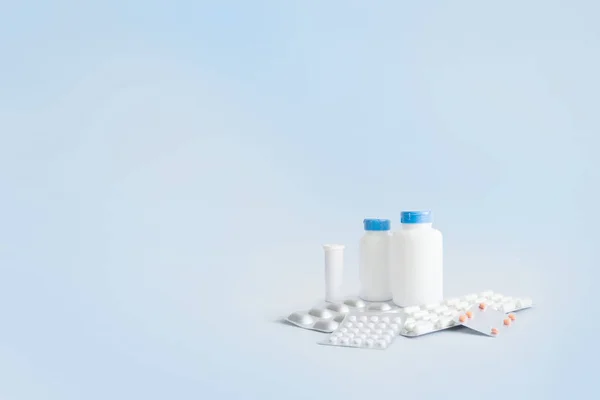 İlaçlar ve vitaminler için beyaz kavanozlar, paketlerdeki haplar.