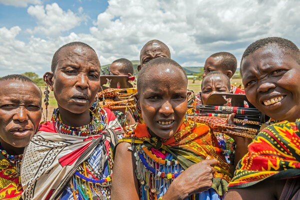 Group of Maasai people with traditional jewelry selling their ho