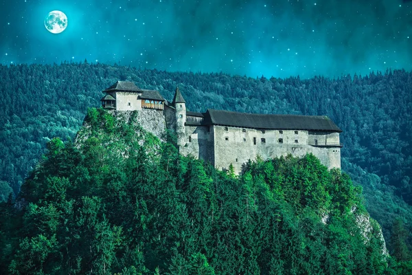 Scary castle in a forest at night with moon — Stock Photo, Image