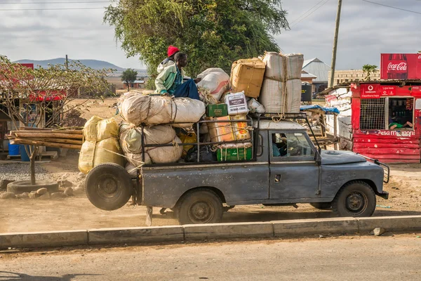 African men transporting goods in an old car — Stock Photo, Image
