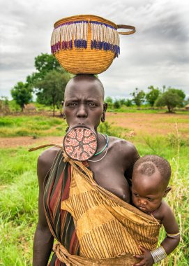 Woman from the african tribe Mursi with her baby
