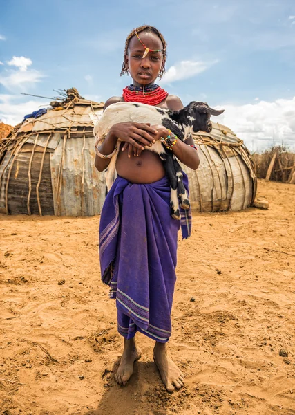 Girl from the African tribe Dasanesh holding a goat — Stock Photo, Image