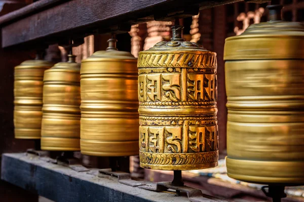 Golden tibetan prayer wheels in a Buddhist temple in Nepal — Stock fotografie