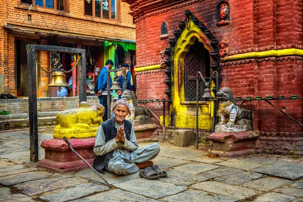 Starší žebrák se modlí v ulici Káthmándú — Stock fotografie