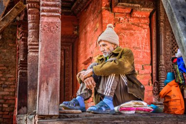 Elderly man begging at Pashupatinath Temple complex in Kathmandu