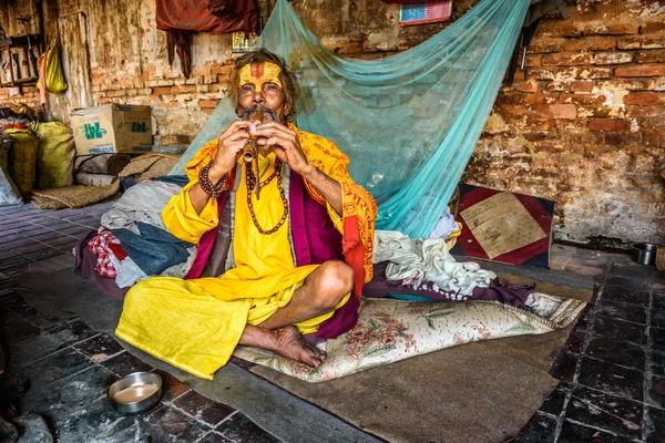 Sadhu baba (homem santo) toca um cachimbo no Templo Pashupatinath, Nepa — Fotografia de Stock