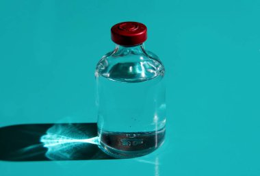 Renkli bir arka planda şeffaf bir sıvıyla bir baloncuk. Tıbbi ürün kavramı..